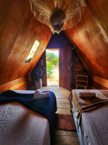 ein Schlafzimmer mit zwei Betten in einem Zimmer mit Holzwänden in der Unterkunft Pousada Recanto da Gê in Buíque