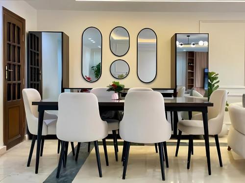 Un comedor con mesa y espejos. en Coze Suite Nile River, en El Cairo