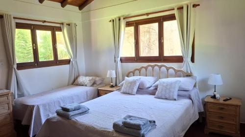 ein Schlafzimmer mit zwei Betten mit Handtüchern darauf in der Unterkunft Cabañas lodge El Suizo in Gobernador Virasora