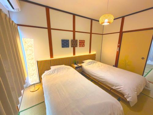 a room with two beds in a room at MM HOUSE Near Takamatsu Station 徒歩3分無料駐車場1台有り in Takamatsu