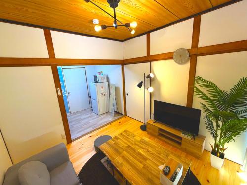 a living room with a television and a table at MM HOUSE Near Takamatsu Station 徒歩3分無料駐車場1台有り in Takamatsu