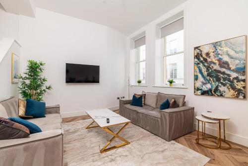 een woonkamer met twee banken en een tv bij Penthouse Collection by EPIC in Liverpool