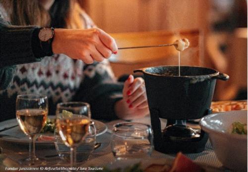 a person is stirring a pot on a table at L'aube de Vouglans 2 Personnes in Pont-de-Poitte