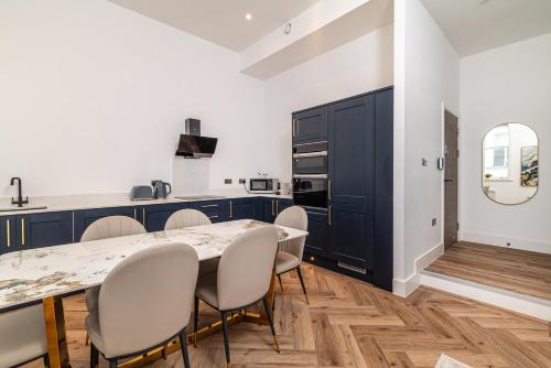 een keuken met een eettafel en stoelen bij Penthouse Collection by EPIC in Liverpool
