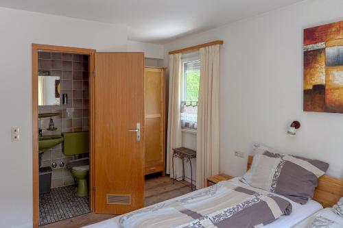 ein Schlafzimmer mit einem Bett und ein Badezimmer in der Unterkunft Gasthaus Talblick - Schwarzwald Plus Karte inkludiert in Baiersbronn
