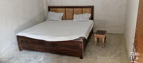 een slaapkamer met een groot bed met een houten hoofdeinde bij SK HOTEL & Restaurant in Prayagraj