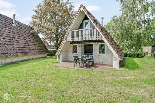 Ce cottage dispose d'une cour avec une table et des chaises. dans l'établissement Mooie rustige woning Overijssel, à Gramsbergen
