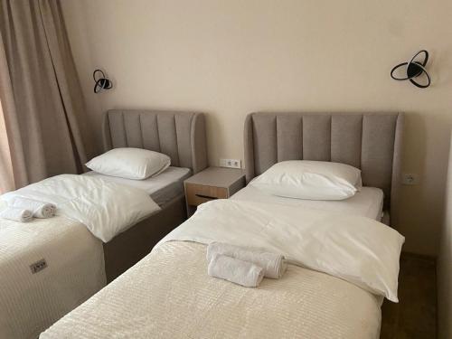 a room with two beds with white sheets at Maganiskhedi in Mtskheta