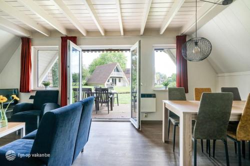ein Esszimmer und ein Wohnzimmer mit Tisch und Stühlen in der Unterkunft Mooie rustige woning Overijssel in Gramsbergen