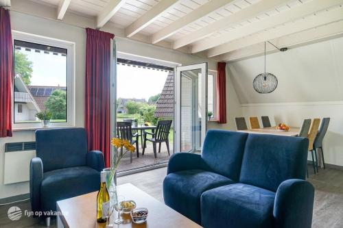 un salon avec un canapé bleu et une table dans l'établissement Mooie rustige woning Overijssel, à Gramsbergen