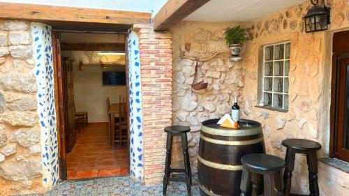a room with a wine barrel and two stools at Casa Cueva Toni in Alcalá del Júcar