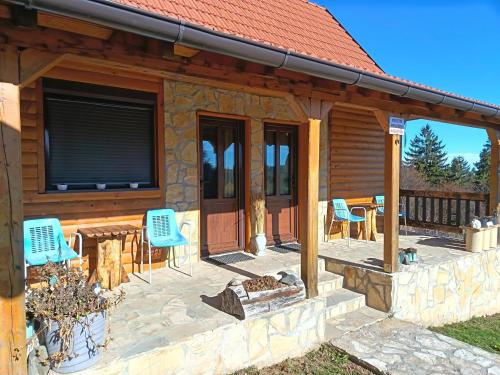 porche de una cabaña de madera con sillas y mesa en Tarin zov, en Kaludjerske Bare
