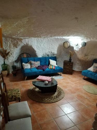 a living room with a blue couch and a table at Casa Cueva Toni in Alcalá del Júcar