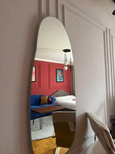 a mirror reflecting a bedroom with a bed and a couch at n'PrishtinëApartments - Apartment 401 in Prishtinë