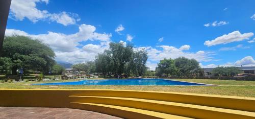 eine gelbe Bank vor einem Swimmingpool in der Unterkunft Vistas del Yásta cabaña para un solo grupo in Cafayate