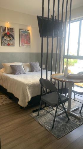 ein Schlafzimmer mit einem Bett, einem Stuhl und einem Tisch in der Unterkunft Studio Coral en la mejor Zona de Cochabamba in Cochabamba