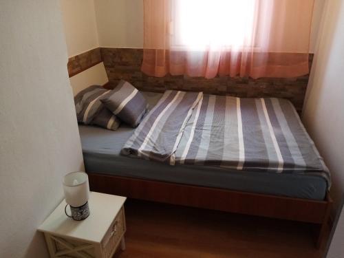 un piccolo letto in una piccola stanza con finestra di Apartment Buic a Pola (Pula)