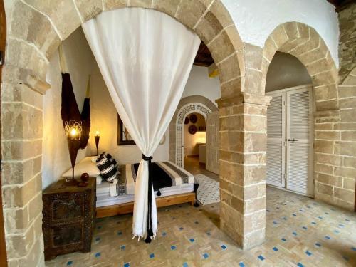 ein Schlafzimmer mit einem Bett in einem steinernen Torbogen in der Unterkunft Maison beldi Essaouira in Rabat
