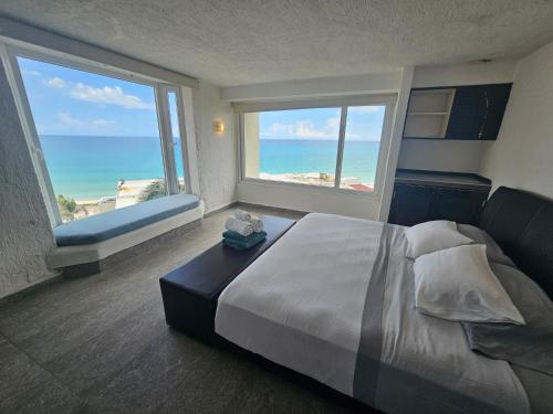 a bedroom with a bed and a view of the beach at Beachfront condos in Cancún