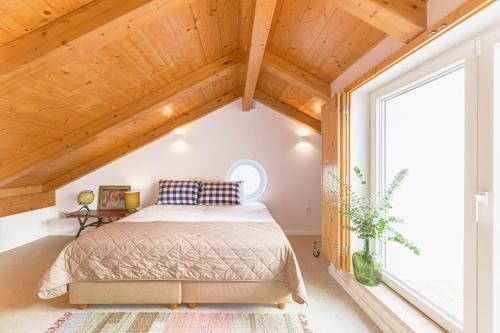 a bedroom with a bed and a large window at Casa do Medronheiro in Melides