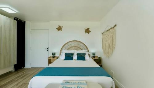 a bedroom with a large bed with blue pillows at Le PARADIS BLEU VUE MER in Saint-François