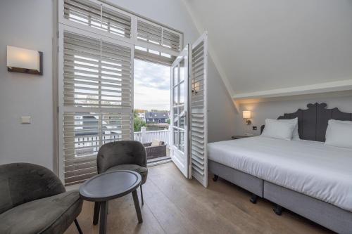 une chambre avec un lit et une grande fenêtre dans l'établissement Fletcher Hotel - Restaurant Nautisch Kwartier, à Huizen