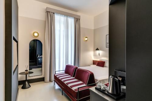 ein Hotelzimmer mit einem Bett und einem Stuhl in der Unterkunft Adaram Suites in Neapel