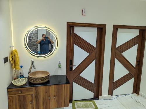 ein Mann, der ein Foto von einem Badezimmer mit einem Spiegel macht in der Unterkunft The Agra Lux- Elite Villa in Agra