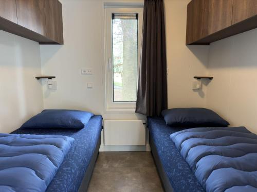 due letti blu in una stanza con una finestra di Ommerland a Ommen