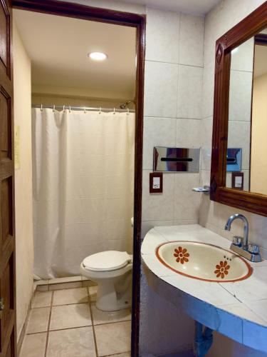 a bathroom with a toilet and a sink at Hotel Hacienda María Eugenia Acapulco in Acapulco