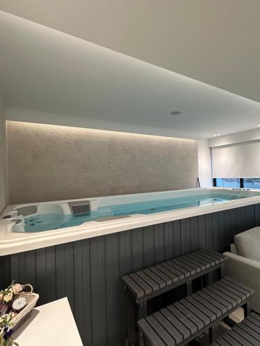 a swimming pool with a bench in front of it at Aurora Residence by A&D Properties in Neos Voutzas