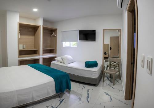 a hotel room with two beds and a television at Hotel Serenity Inn in Cartagena de Indias