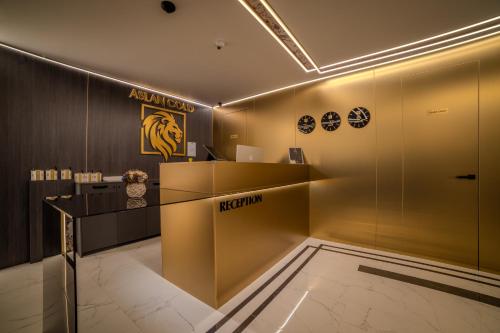 a lobby with a reception desk and a lion sign on the wall at Aslan Gold Hotel in Varna City