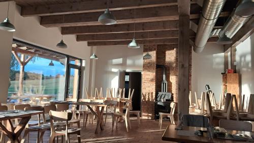 Un restaurante con mesas y sillas y un gran ventanal. en Apartmány a camp Telč - U Roštěnky, en Telč