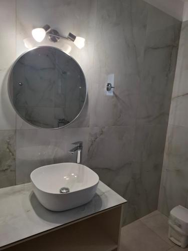 a bathroom with a white sink and a mirror at Βessie's Village in Kefallonia