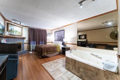 - une chambre d'hôtel avec un lit et une baignoire dans l'établissement Super 8 by Wyndham Gananoque - Country Squire Resort, à Gananoque