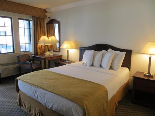 una habitación de hotel con una cama grande y una silla en Arbor Inn Monterey, en Monterey