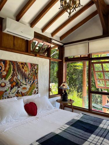 a bedroom with a bed in a room with windows at Guest House Tânia Alves in Pratinha