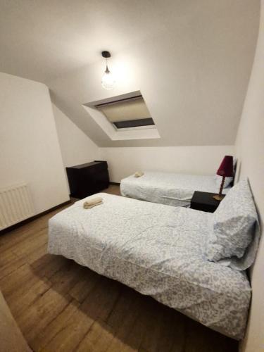 a room with two beds and a couch in it at Le Coty duplex - 5min chantier et 250m plage in Saint-Nazaire