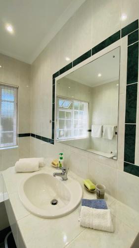 a white bathroom with a sink and a mirror at Bicycle Lodge Apartment in Tokai