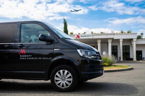 czarny van zaparkowany przed budynkiem z samolotem w obiekcie Paris Marriott Charles de Gaulle Airport Hotel w Roissy-en-France
