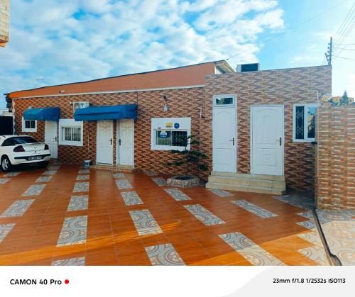 un edificio de ladrillo con puertas blancas y aparcamiento en Kimkeri Hotel, en Ogbojo