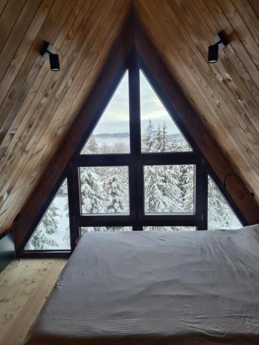 una cama en una habitación con una ventana grande en Gorje Tara, en Sekulić 