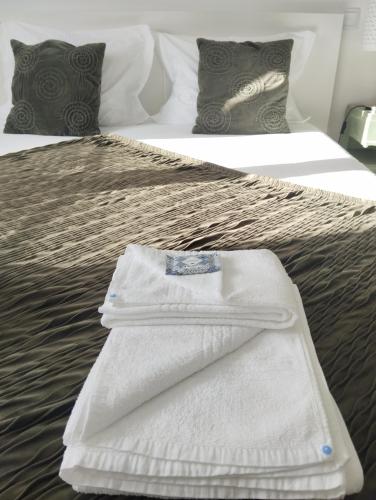 a white towel sitting on top of a bed at Eira da Mila in Coimbra