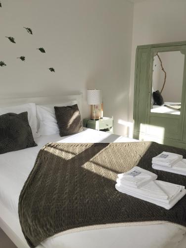 a bed with a blanket on it with a mirror at Eira da Mila in Coimbra