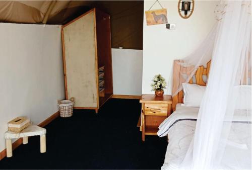 a bedroom with a bed with a canopy at Hotel White Sandcastle Mara Lodge in Sekenani