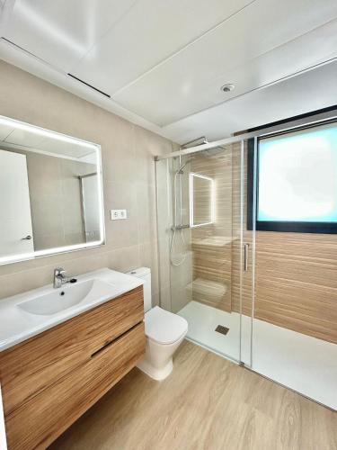 a bathroom with a toilet and a sink and a shower at Les Flors de Cunit Villa Cedra in Cunit