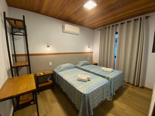 a bedroom with a bed with two towels on it at Venere - Bed and Breakfast in Florianópolis