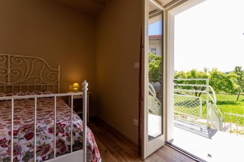 a bedroom with a bed and a sliding glass door at Corte Girodo - Appartamento Girasole in Rubiana