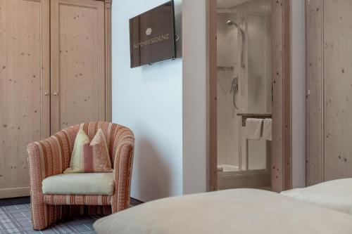 a bedroom with a wicker chair and a shower at Alpenresidenz am Mühlbach in Obergurgl